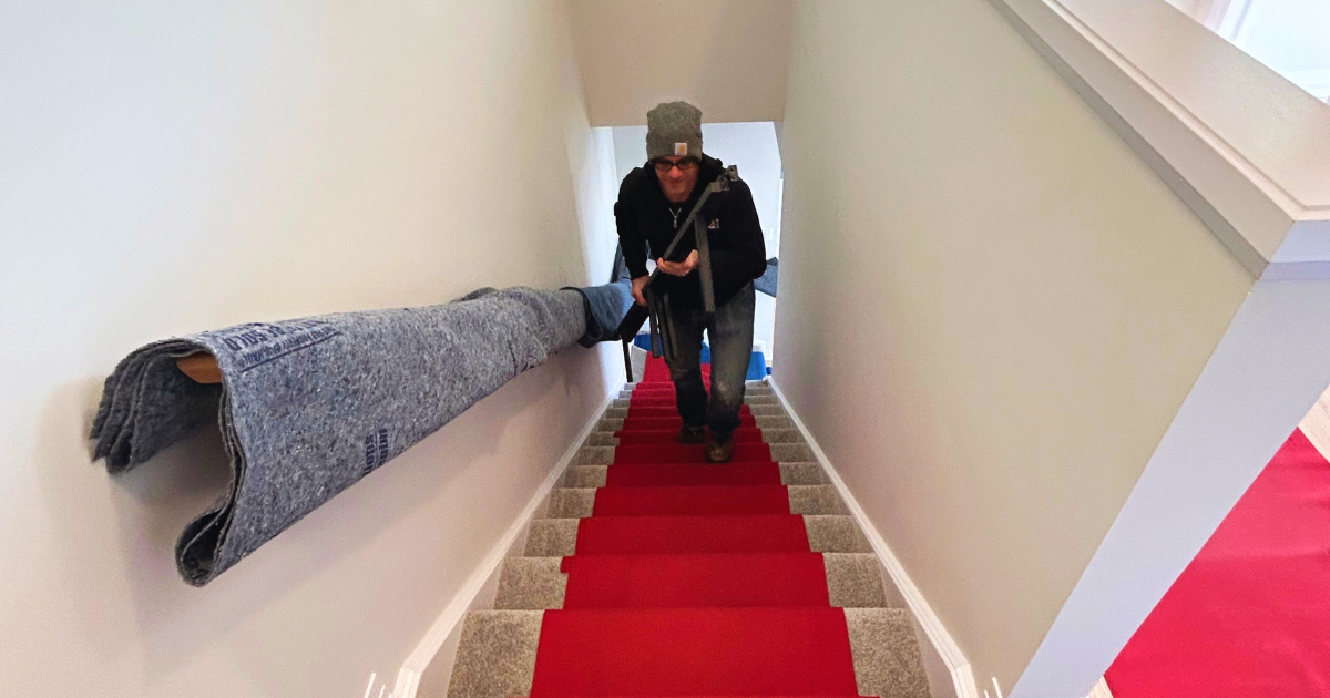Lenny moving things up the stairs with protective material on the stairs